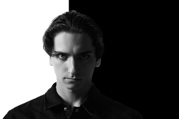 Black and white portrait of young man in classical shirt posing. Seriously looking at camera. Concept of men's fashion, business, emotions