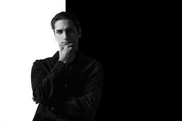 Black and white portrait of young man in classical shirt posing. Serious look. Concept of men's fashion, business, emotions