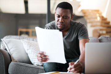 Remote work, living room and black man with paperwork for insurance, investment of home financial. Man reading budget, taxes and documents on a lounge sofa writing document research for online job