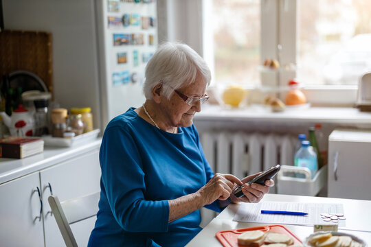 Senior woman using mobile phone at home
