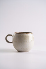 Empty grey ceramic scandy coffee mug with brown rim and round handle on white seamless background,...
