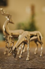 Vertical shot of golden reindeers as toys for christmas on a blurred background