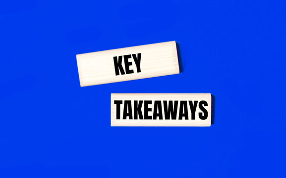 Two wooden blocks with the text KEY TAKEAWAYS on a blue background. Copy space