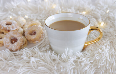 Cozy winter morning breakfast in bed still life scene.Yummy Christmas sweets and steaming cup of hot coffee. Christmas concept.
