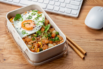 Shrimp fried rice with vegetables and fried egg in a lunch box
