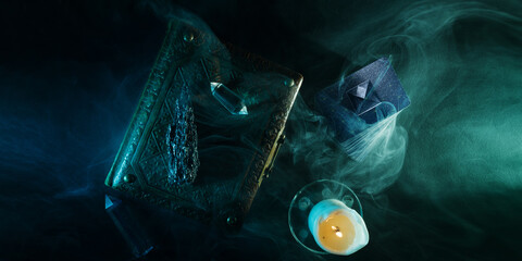 Mystical book of magic and tarot cards for divination on a dark table. Panoramic mockup for your...