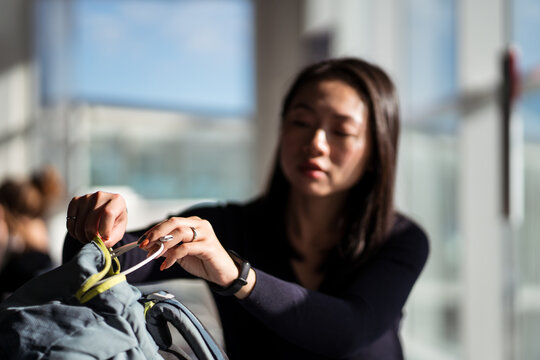Asian traveler taking cord from bag