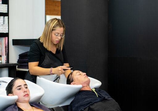 Hairdresser washing hair of clients