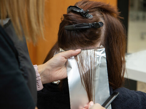 Hairstylist using foil to dye hair