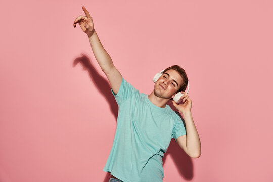 Young male listening to music and dancing