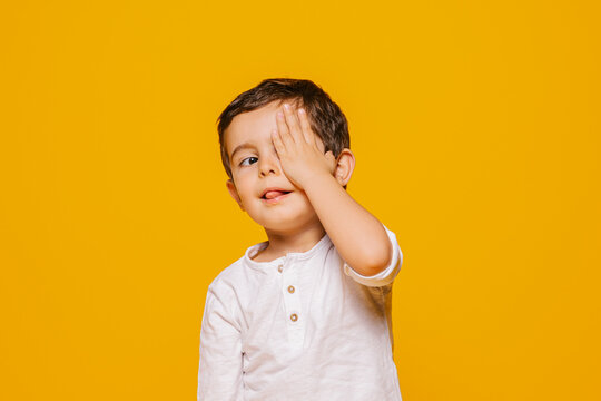 Naklejki Cute little boy looking away and covering face