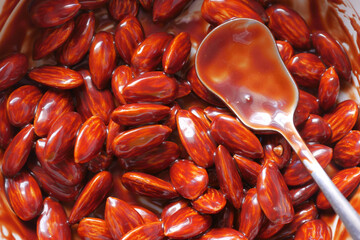 dark chocolate cream pouring on almond nut on white 