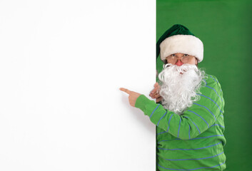 Santa Claus points to a white billboard