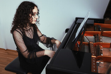 Fototapeta na wymiar Pianist silhouette close up. The girl plays the piano.