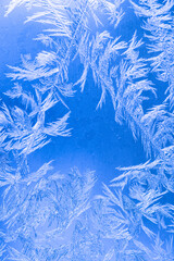 Frozen texture. Frost patterns on frozen window as a symbol of Christmas wonder.