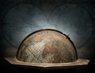 Old geographical globe in cabinet with ancient map. Science, education, travel, vintage background. History and geography team. Ancience, antique globe on the background of map.