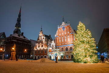 Fototapeta premium People enjoy Christmas market in winter Riga in Latvia. Magical European Christmas market.