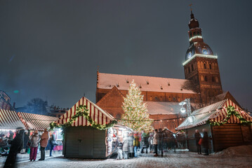 People enjoy Christmas market in winter Riga in Latvia. Magical European Christmas market.