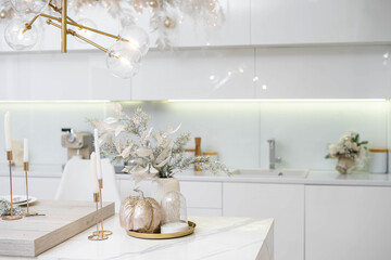 Christmas decor. Bright interior of white kitchen with decorated Christmas tree, garlands and...
