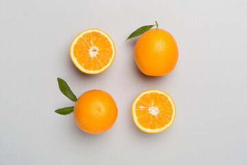 Flat lay with fresh oranges and leaves on color background
