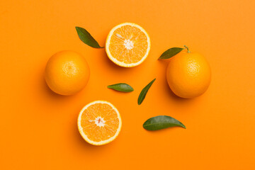 Flat lay with fresh oranges and leaves on color background