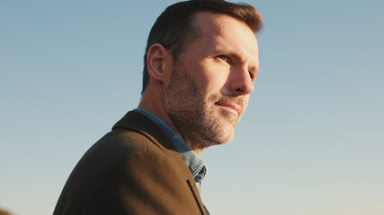 Close up, man looks around on blue sky background