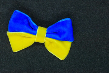 A bow made of blue-yellow fabric as the flag of Ukraine on a black background