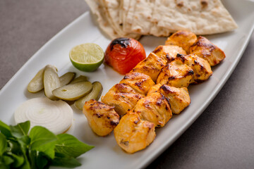 Jujeh chhicken tikka boti kabab with bread and salad served in dish isolated on grey background top view of arabic food