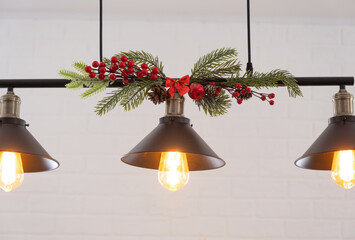 The black lampshade in the industrial loft style is decorated with spruce branches for Christmas...