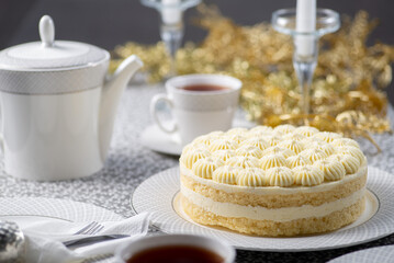 Festive served Christmas table with cake. Family tea party for christmas and new year. Dining table decorated with gold tinsel