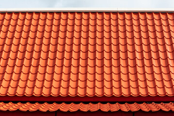Orange roof tiles with sky background.