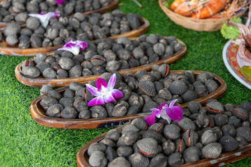 pile of raw cockles on bowl with blur background, in a local market.