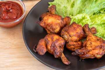 pilons de poulet grillé et ketchup sur une table	