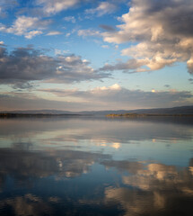 Beautiful landscape. Lake water surface with reflection of clouds in the water