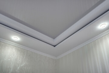 suspended ceiling with halogen spots lamps and drywall construction  with intricate crown molding...