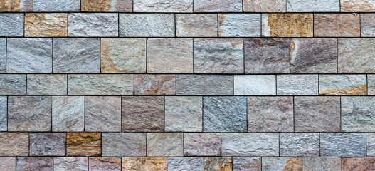 Beautiful wall of cut stone blocks. Panoramic view of urban texture with colorful stone brick wall.