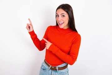 Young caucasian woman wearing red sweater over white background points at copy space indicates for advertising gives right direction