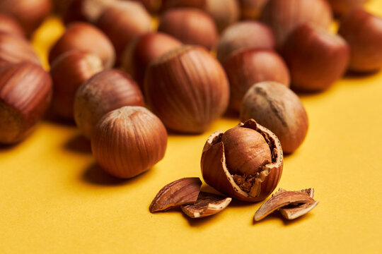 Cracked hazelnut on yellow background