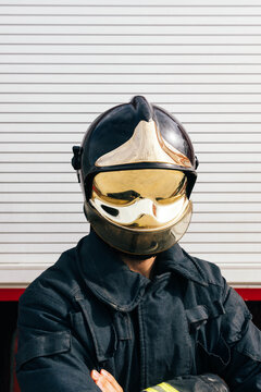Anonymous confident fireman in uniform and helmet