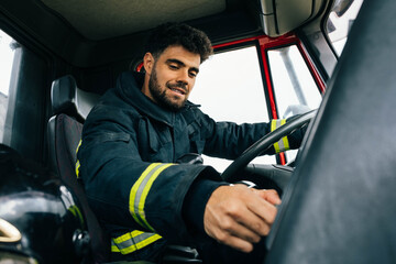 Fireman driving fire engine in daytime