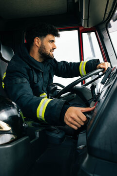 Fireman driving fire engine in daytime