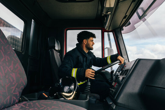Hispanic fireman driving fire engine