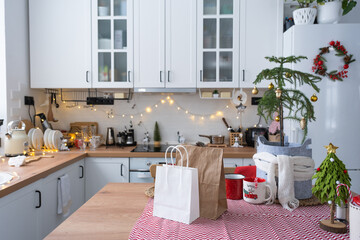 Food delivery service containers on table white scandi festive kitchen in christmas decor. Eve New year, saving time, too lazy to cook, hot order, disposable plastic box in fairy light. mock up