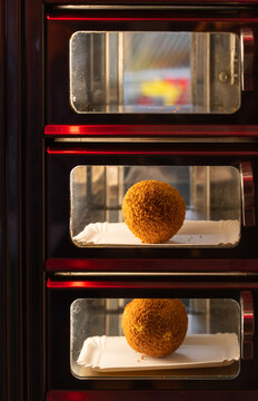 Eierbal in vending machine, dutch fried snack popular at the north of the country which consists of hard-boiled egg, ragout and breadcrumbs. Selective focus