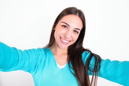 Photo Of Young Caucasian Woman Wearing Blue Sweater Over White Background Do Selfie