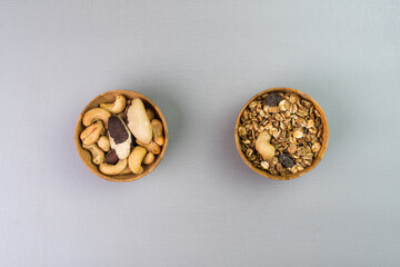 Bamboo pots with cashew nuts, Brazil nuts and granola on the side. Top view. Selective focus