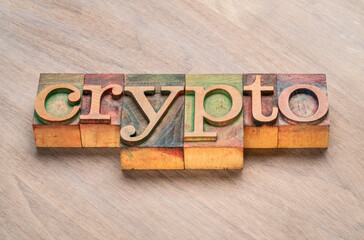 crypto - word abstract in letterpress wood type against grained wooden background, digital money, cryptocurrency and business concept