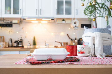 Food delivery service containers on table white scandi festive kitchen in christmas decor. Eve New year, saving time, too lazy to cook, hot order, disposable plastic box in fairy light. mock up