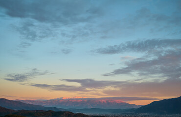 Sunset over the city of Fethiye, Akdag ridge, view of the city of Uyluk-Tepe in the snow. Winter in the Aegean. Background for advertising vacation or travel, idea for wallpaper