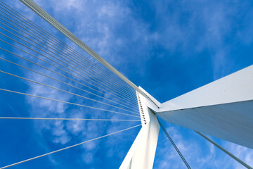 Steel cables and white metal construction from frog perspective with blue sky. Diagonal lines and...